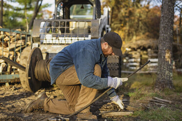 Man working on field by tractor - CAVF24363