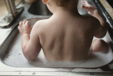 Rear view of boy bathing in sink - CAVF24435