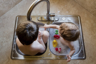Hochformatige Ansicht von Brüdern, die mit Wasser im Waschbecken spielen - CAVF24459