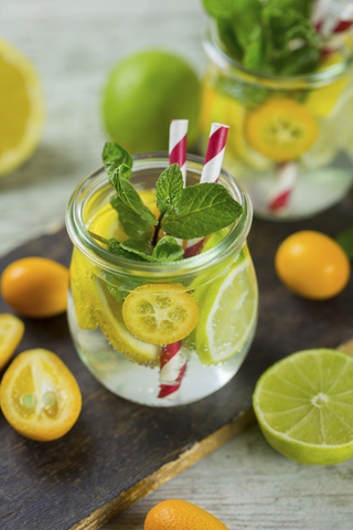 Infusionswasser mit Limette, Zitrone, Kumquat und Minze, lizenzfreies Stockfoto