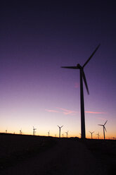 Wind turbines on field against clear sky during sunset - CAVF24542