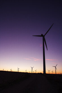 Wind turbines on field against clear sky during sunset - CAVF24542