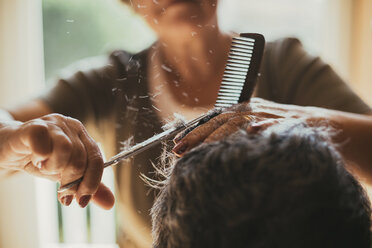 Mittelteil einer Friseurin, die einem männlichen Kunden die Haare schneidet - CAVF24549