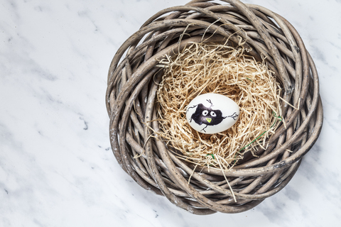 Bemaltes Osterei im Nest mit Stroh, lizenzfreies Stockfoto