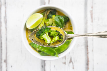 Grünes Thaicurry mit Brokkoli, Pak Choi, Zuckerschoten, Babyspinat, Limette, Brokkoli und Sauce auf Löffel - LVF06817