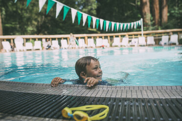 Glücklicher Junge schaut beim Schwimmen im Pool weg - CAVF24651