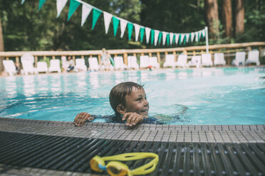Happy boy looking away while swimming in pool - CAVF24651