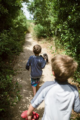 High angle view of brothers carrying shoes while walking on field amidst plants at A_o Nuevo State Park - CAVF24677