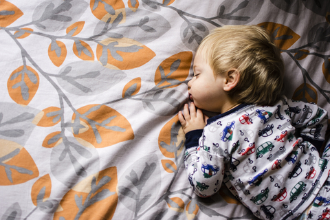 Hoher Blickwinkel auf einen schlafenden Jungen im Bett, lizenzfreies Stockfoto