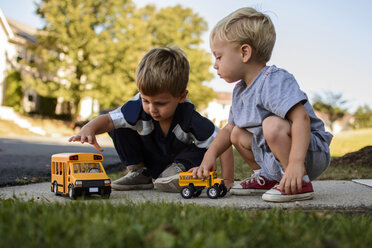 Brothers playing with toys in backyard - CAVF24738