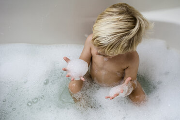 High angle view of boy playing with soap sud while bathing in bathtub - CAVF24739