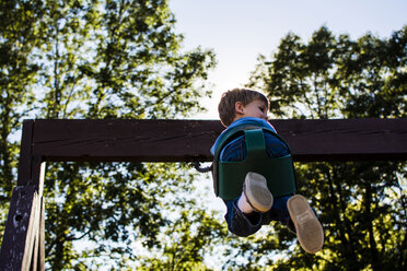 Niedriger Blickwinkel des Jungen schaukeln gegen den Himmel auf dem Spielplatz - CAVF24761