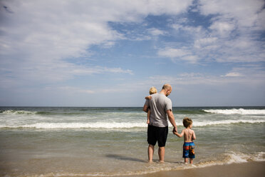 Rückansicht einer Familie, die am Strand gegen den Himmel an einem sonnigen Tag genießt - CAVF24778