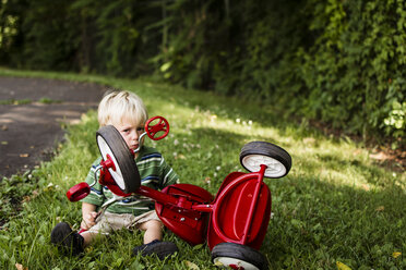 Porträt eines Jungen mit Fahrrad auf einer Wiese - CAVF24780