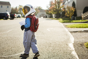 Junge mit Weltraumhelm auf der Straße in der Stadt - CAVF24803