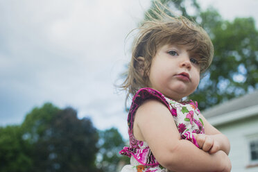 Portrait of cute girl standing against cloudy sky in backyard - CAVF24817