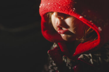 Close-up of girl wearing hood clothing in dark room - CAVF24823