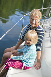 Mutter und Tochter sitzen an Deck eines Bootes - FOLF00006