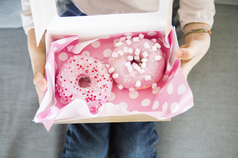 Mädchen hält Schachtel mit Doughnuts, Teilansicht, lizenzfreies Stockfoto