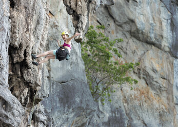 Thailand, Krabi, Lao Liang, happy woman climbing in rock wall - ALRF01022