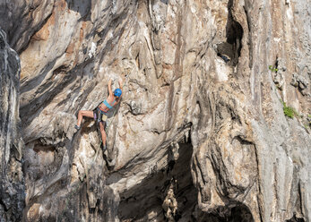 Thailand, Krabi, Lao Liang, woman climbing in rock wall - ALRF01026