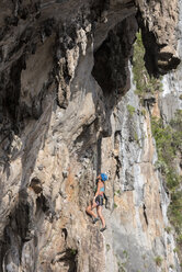 Thailand, Krabi, Lao Liang, woman climbing in rock wall - ALRF01027