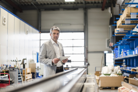 Businessman using tablet in production hall stock photo