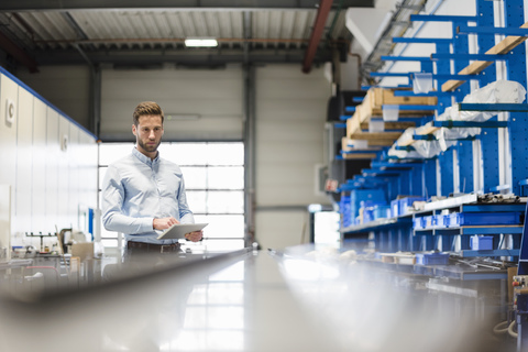 Geschäftsmann mit Tablet in der Produktionshalle, lizenzfreies Stockfoto