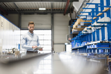 Businessman using tablet in production hall - DIGF03506