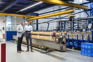 Businessmen during meeting with clipboard in production hall - DIGF03510