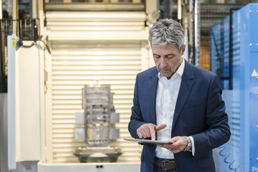 Businessman using tablet in production hall - DIGF03525