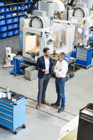 Businessmen during meeting in production hall stock photo