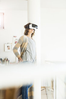 Woman wearing VR glasses at home - MOEF00926