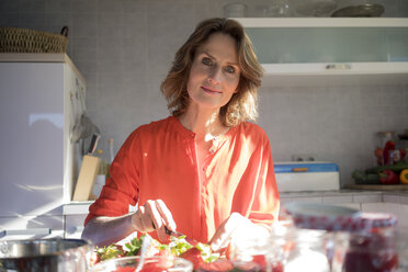 Porträt einer Frau, die zu Hause in der Küche Erdbeermarmelade macht - MOEF00927
