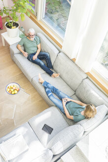 Älteres Paar entspannt sich auf der Couch zu Hause - MOEF00935