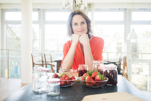 Portrait of woman with homemade strawberry jam at home - MOEF00938