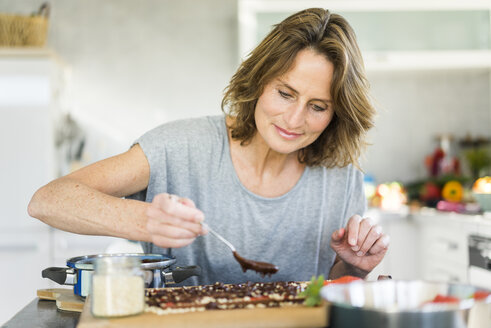 Woman making strawberry chocolate in kitchen at home - MOEF00953