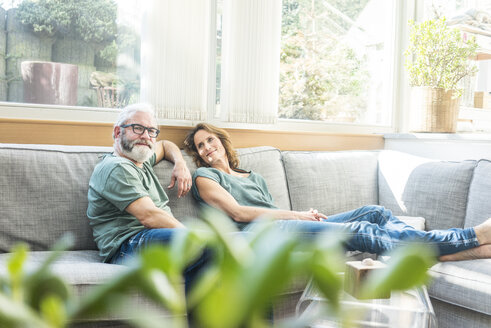 Älteres Paar entspannt sich auf der Couch zu Hause - MOEF00956