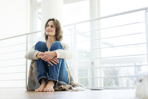 Relaxed woman sitting on the floor at home - MOEF00963