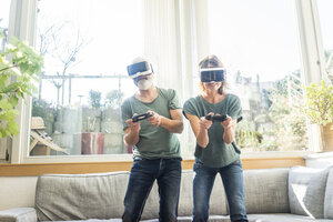 Reifes Paar in Kiving-Zimmer zu Hause mit VR-Brille spielen Videospiel - MOEF00968