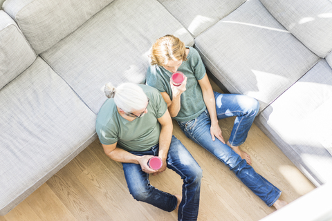 Mature couple with healthy drinks in living room at home stock photo