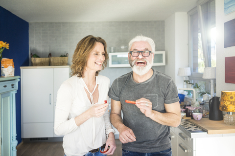 Lachendes reifes Paar in der Küche zu Hause, lizenzfreies Stockfoto
