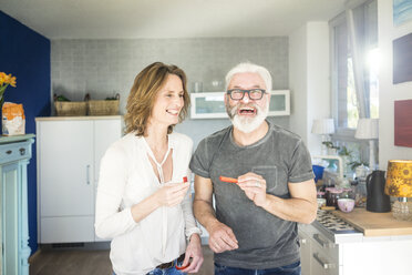 Laughing mature couple in kitchen at home - MOEF00986