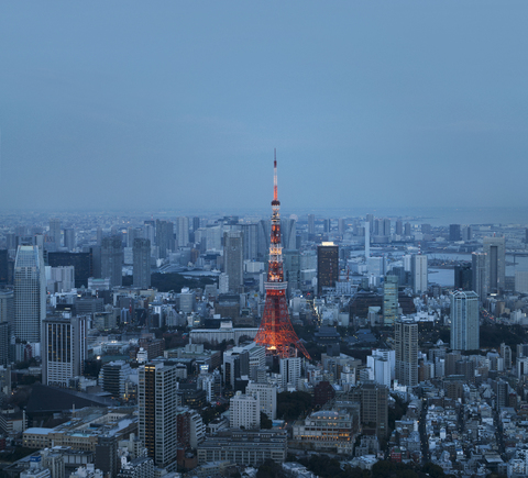 Luftaufnahme des beleuchteten Tokio-Turms inmitten der Stadt in der Abenddämmerung, lizenzfreies Stockfoto