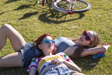 Freundinnen entspannen sich auf einer Wiese im Park - CAVF24908