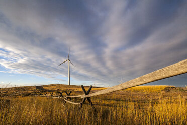 Windmills and wooden fence on field against cloudy sky - CAVF24919