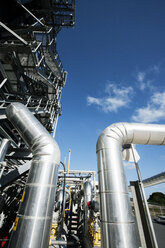 Niedriger Blickwinkel auf Pipelines in der Industrie vor blauem Himmel - CAVF24947