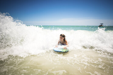 Mädchen surft im Meer gegen klaren Himmel - CAVF25059