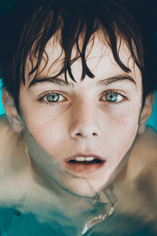 Hohe Winkel Porträt des Jungen Schwimmen im Pool, lizenzfreies Stockfoto