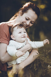 Happy mother carrying son at forest - CAVF25086